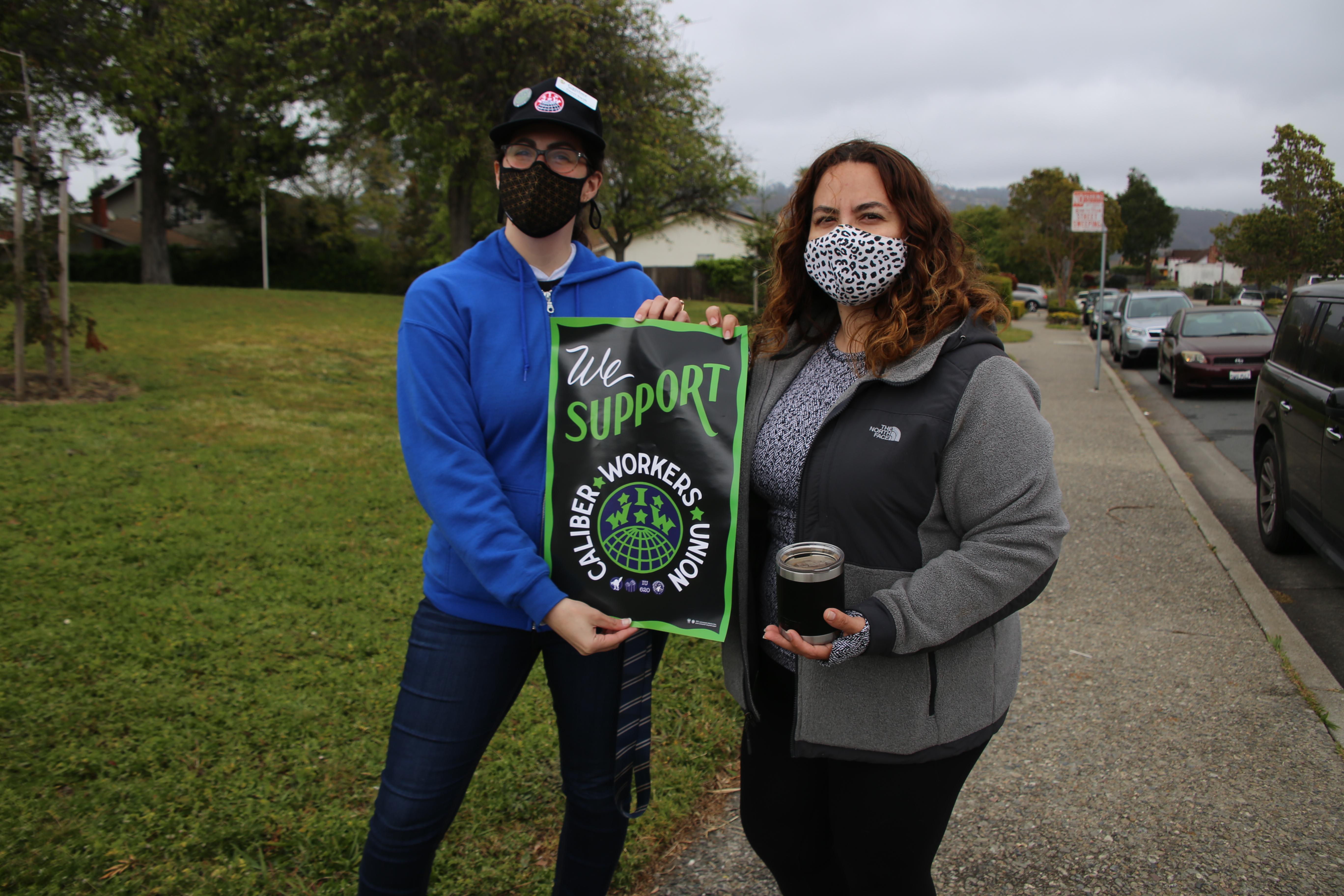 Two student holding a sign in support of their teachers' union, the Caliber Workers Union.